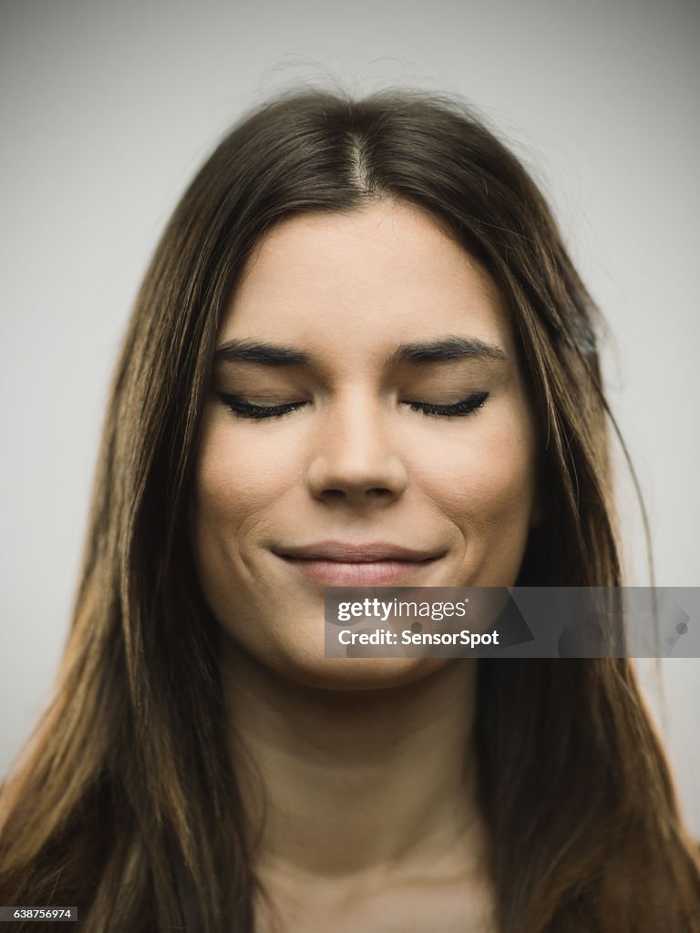 Excited woman smiling against gray background