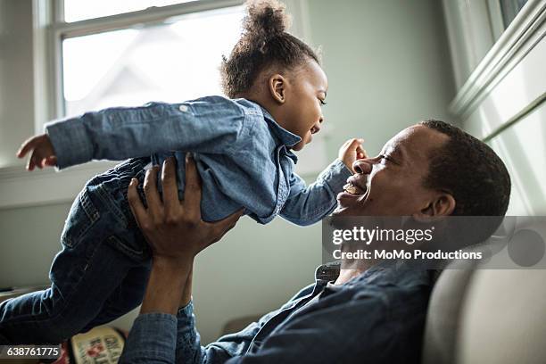 father holding toddler daughter - african american dad stock-fotos und bilder