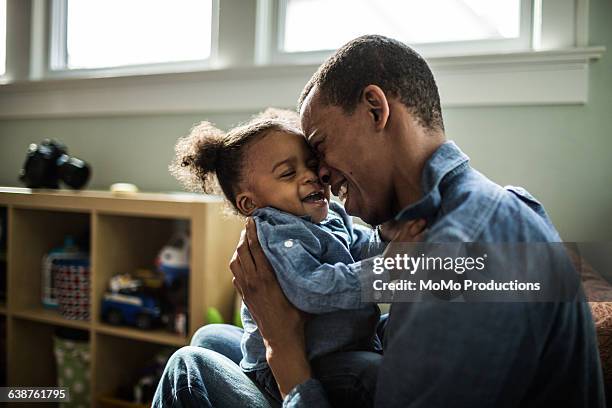 father laughing with toddler daughter - black baby foto e immagini stock