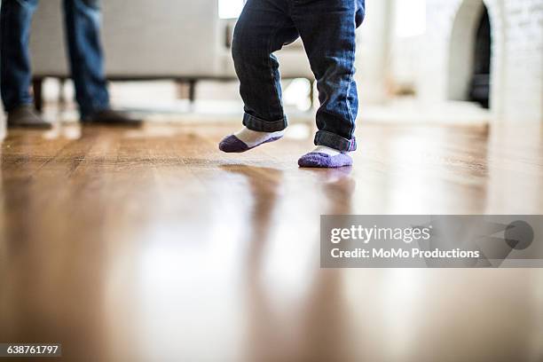 toddler taking 1st steps - learning to walk stockfoto's en -beelden