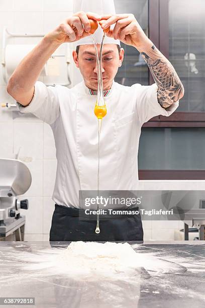 chef cracking egg in a heap of flour - chef patissier stock pictures, royalty-free photos & images