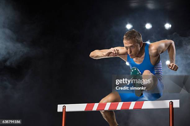 athlete jumping over hurdle - track and field event stock pictures, royalty-free photos & images