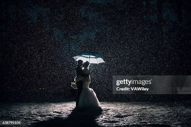 wedding couple in the rain and snow - bruidegom stockfoto's en -beelden