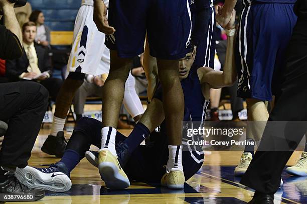 Yuta Watanabe of the George Washington Colonials is helped up after fouling the La Salle Explorers during the second half at Tom Gola Arena on...