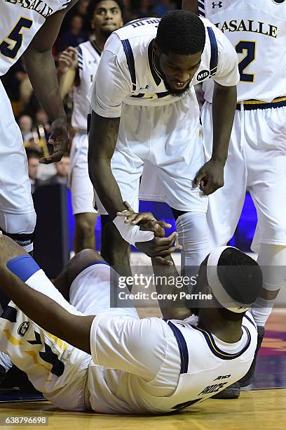 Jordan Price is helped up by B.J. Johnson of the La Salle Explorers against the George Washington Colonials during the second half at Tom Gola Arena...