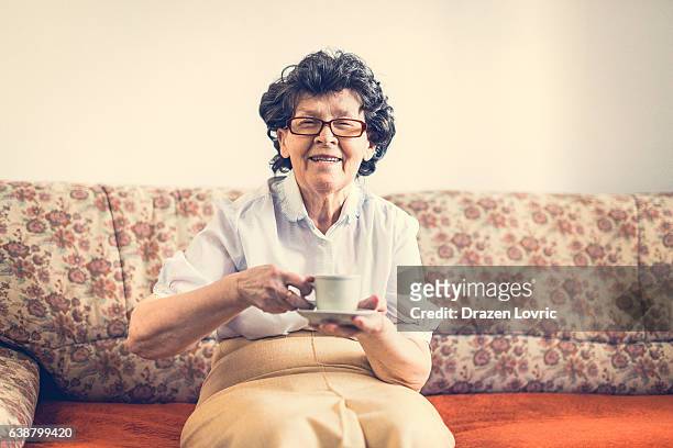 aging with smile - senior woman drinking coffee - oost europese cultuur stockfoto's en -beelden
