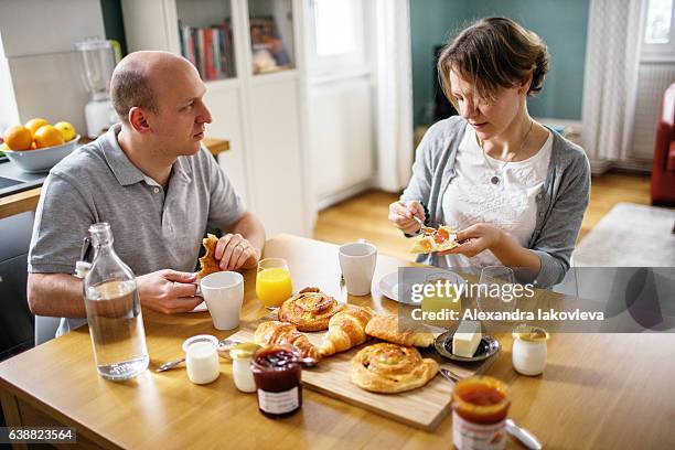 happy french couple eating breakfast at home - alexandra iakovleva stock pictures, royalty-free photos & images