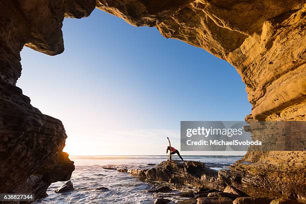 women in salutation pose in an ocean cave - san diego people stock pictures, royalty-free photos & images