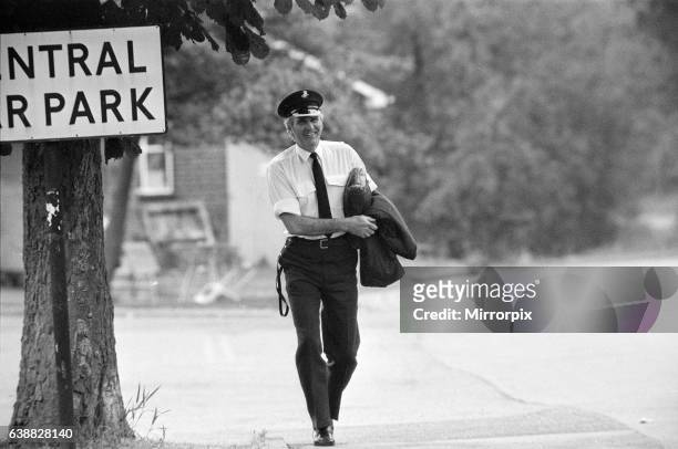 Policeman watches as Michael Peterson stages a protest on the roof of Broadmoor Hospital. 20th June 1983.