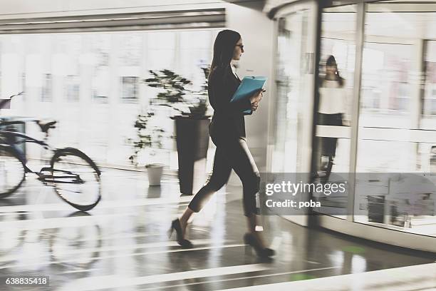 empresaria caminando en el vestíbulo - revolve fotografías e imágenes de stock