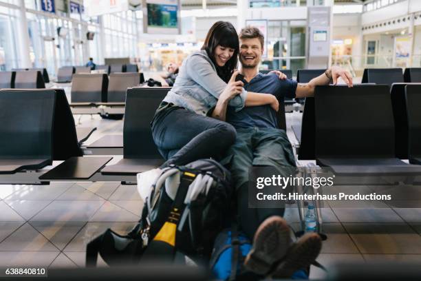 couple in airport departure lounge - backpacker airport stock pictures, royalty-free photos & images