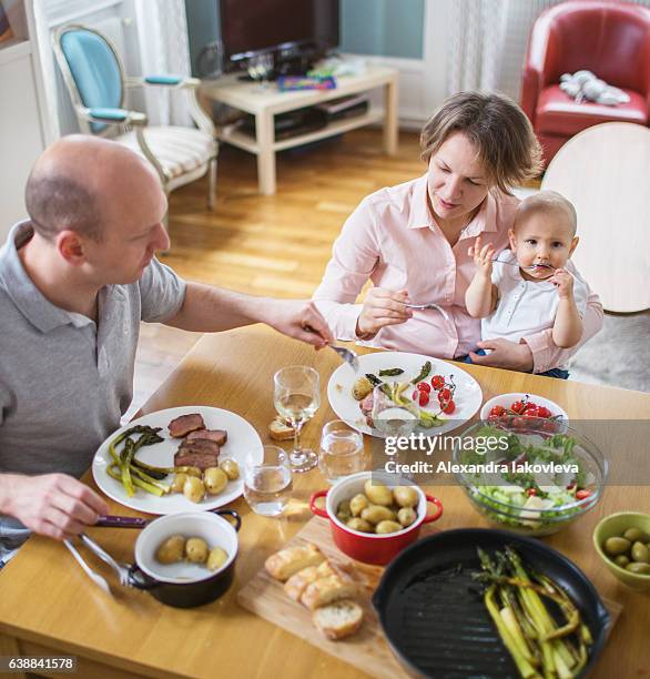 happy family eating lunch together at home - alexandra anka bildbanksfoton och bilder