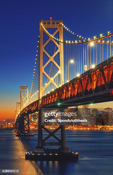 bay bridge and san francisco skyline at sunset - san francisco oakland bay bridge stockfoto's en -beelden