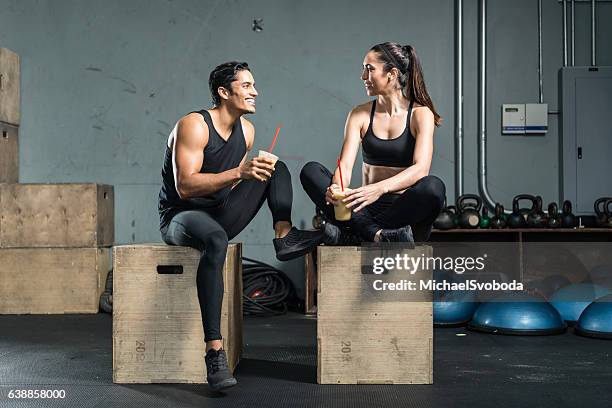 hispanic fitness couple drinking a smoothie - calcio sport imagens e fotografias de stock
