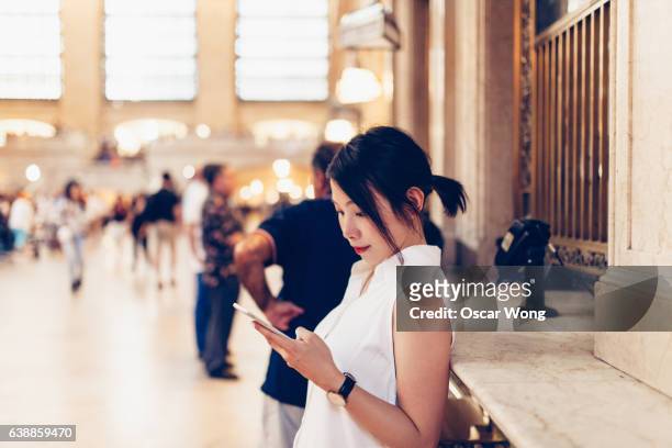 young tourist buying ticket online at grand central terminal, new york - grand central tours stock pictures, royalty-free photos & images