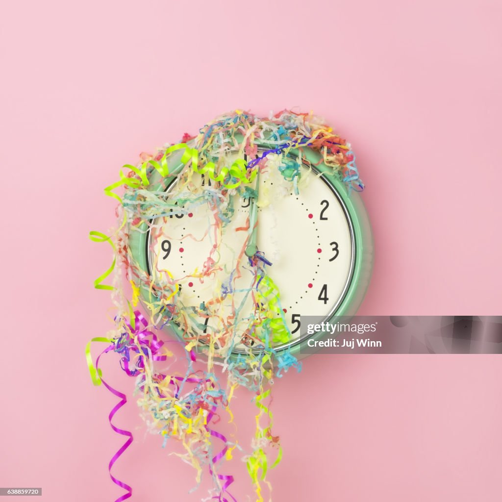 Clock covered in confetti and party streamers