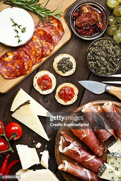 delicioso aperitivo sobre mesa de madera rústica - antipasto fotografías e imágenes de stock