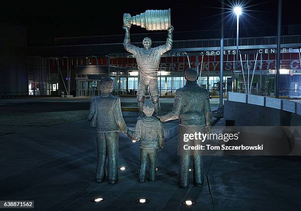 Statue of Wayne Gretzky of the Edmonton Oilers hoisting the Stanley Cup in the distance as a younger Wayne Gretzky with his mother Phyllis and father...