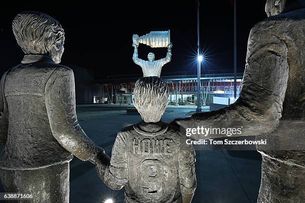 Statue of Wayne Gretzky of the Edmonton Oilers hoisting the Stanley Cup in the distance as a younger Wayne Gretzky with his mother Phyllis and father...