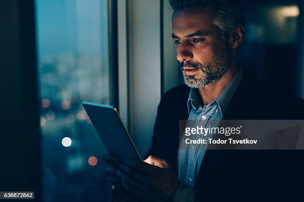 buisnessman mit tablet bei nacht - elegant man night stock-fotos und bilder