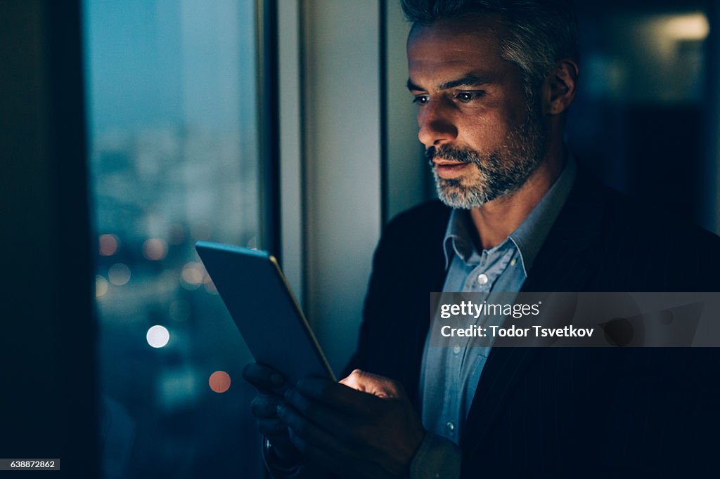 Buisnessman Using Tablet At Night