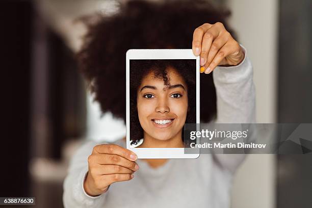 mixed race woman taking selfie with tablet - digital identity stockfoto's en -beelden