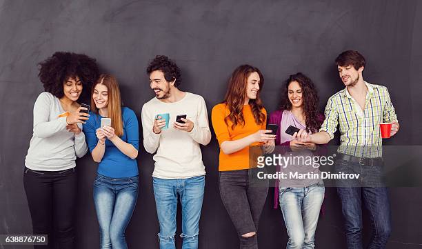 friends texting on smartphones - rumor 個照片及圖片檔