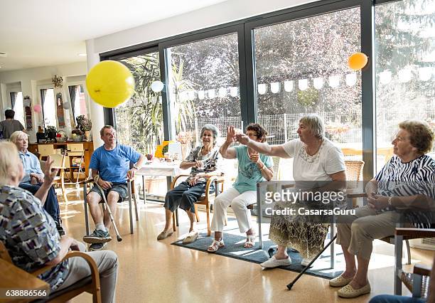 personas mayores que participan en actividades grupales en la guardería para adultos - leisure activity fotografías e imágenes de stock