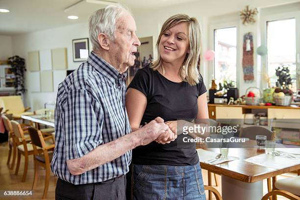 adult daycare center lifestyle - old man young woman stock pictures, royalty-free photos & images