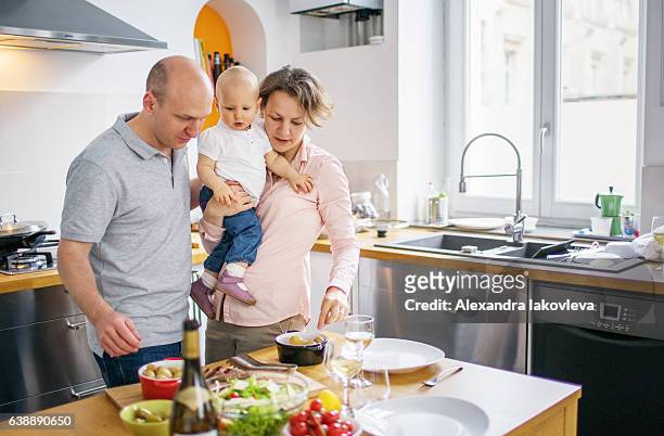 family cooking lunch together at home - iakovleva stock pictures, royalty-free photos & images