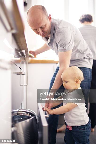 family cooking lunch together at home - alexandra iakovleva stockfoto's en -beelden