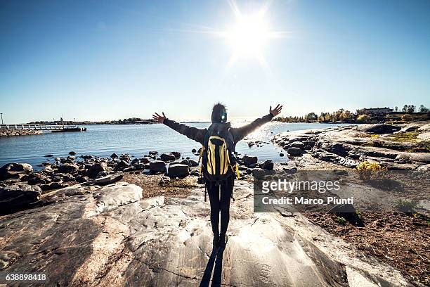 travel woman arms outstretched by the sea - finland stock pictures, royalty-free photos & images