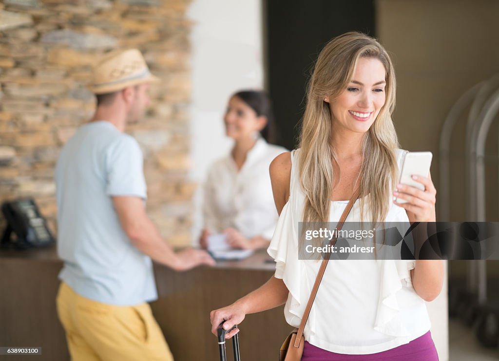 Reisende im Hotel mit App auf ihrem Handy