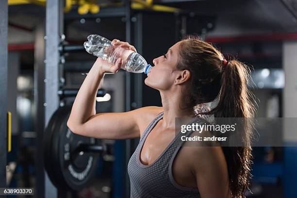 frau im fitnessstudio trinkwasser - woman drinking water from bottle stock-fotos und bilder