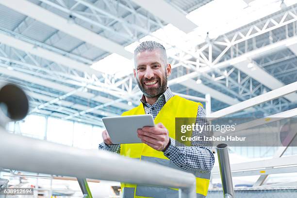 aircraft engineer using a digital tablet in a hangar - aviation engineering stockfoto's en -beelden
