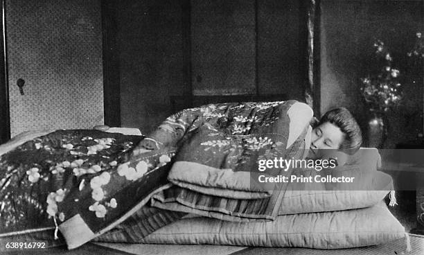 Saki, the housekeeper sleeps on a mattress with hard pillow under a quilted kimono', c1900, . From Mysterious Japan, by Julian Street. [Doubleday,...