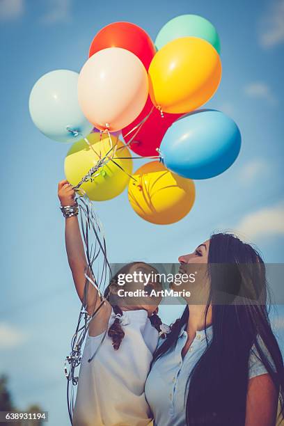 mother and daughter with balloons - balloon kid stockfoto's en -beelden
