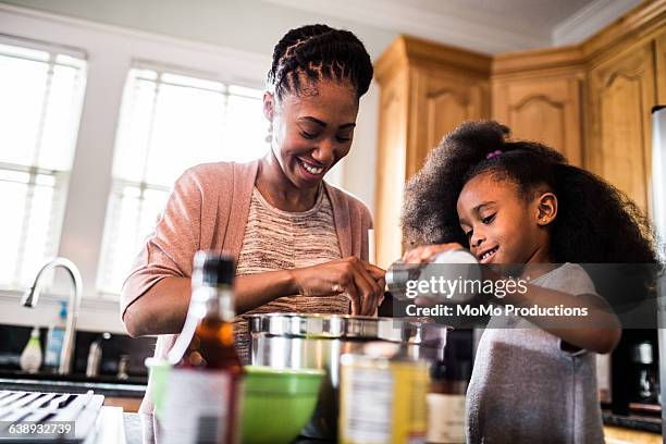 mother and daughter cooking at home - black mother and child cooking stock-fotos und bilder