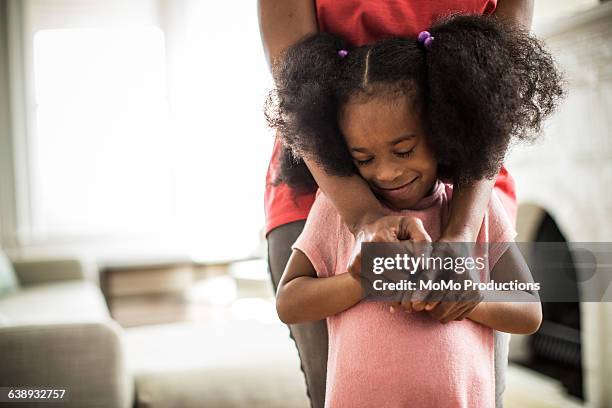 mother's arms embracing daughter - mama kind kuscheln stock-fotos und bilder