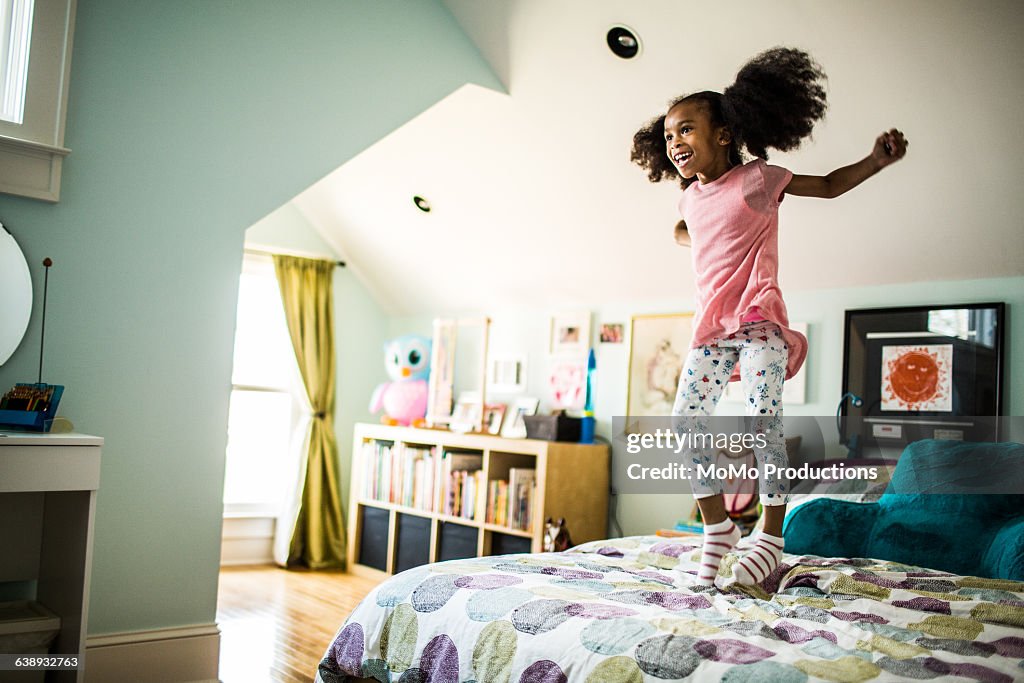 Girl jumping on bed