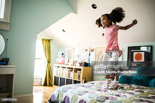 girl jumping on bed - colourful home stock pictures, royalty-free photos & images