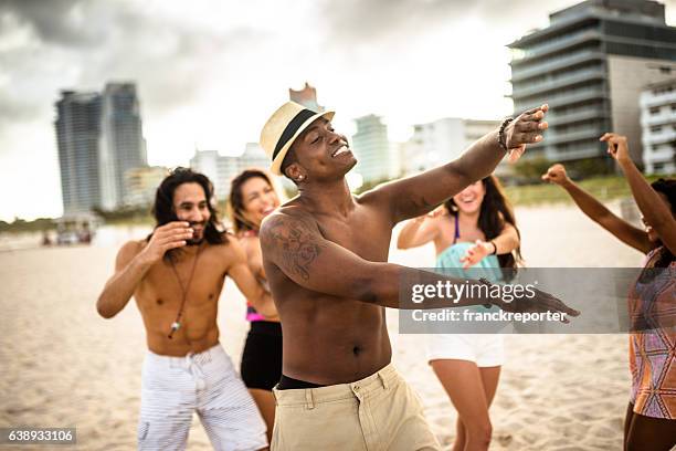 friends dancing on the beach for a party - lens flare young people dancing on beach stock pictures, royalty-free photos & images