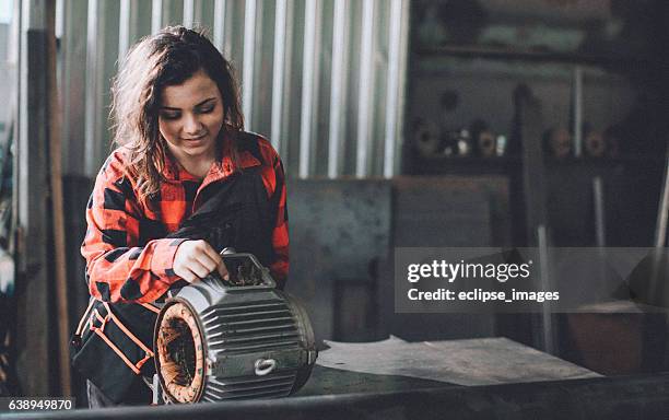 woman machinist examining electric motor with voltmeter - voltmeter stock pictures, royalty-free photos & images
