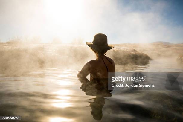 a woman relaxing in a hot spring. - fonte termal imagens e fotografias de stock