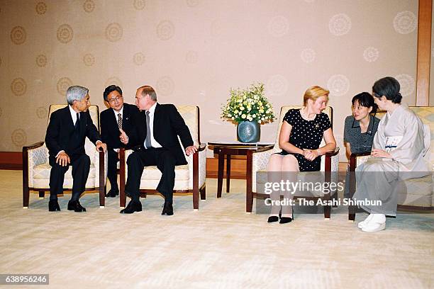 Russian President Vladimir Putin and Emperor Akihito talk while Empress Michiko and Putin's wife Lyudmila talk during their meeting at the Imperial...