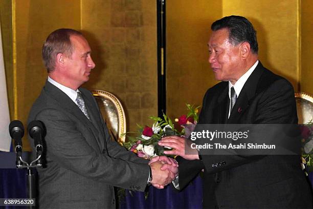 Russian President Vladimir Putin and Japanese Prime Minister Yoshiro Mori shake hands after a joint press conference following their meeting at the...