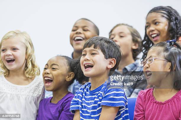 multi-ethnic group of children sitting together shouting - singing for kids stock pictures, royalty-free photos & images