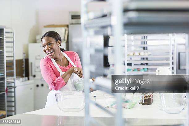 femme afro-américaine travaillant dans la cuisine de boulangerie - boulangerie industrielle photos et images de collection