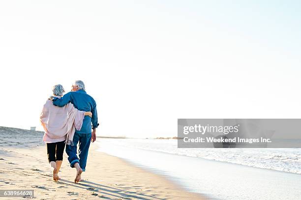il modo migliore per trascorrere le vacanze - couple walking on beach foto e immagini stock