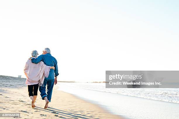 best way to spend vacations - couple walking on beach stock pictures, royalty-free photos & images